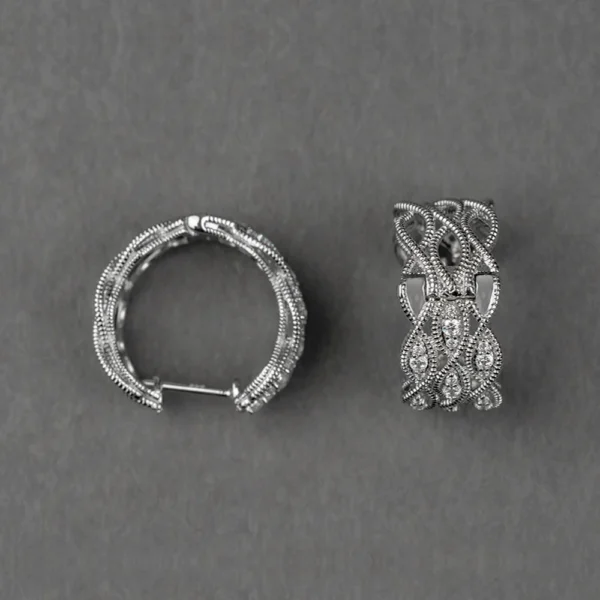 Pair of wide white gold or silver huggie hoop earrings featuring an intricate vintage-style openwork lattice design with milgrain beading and pavé-set clear stones.