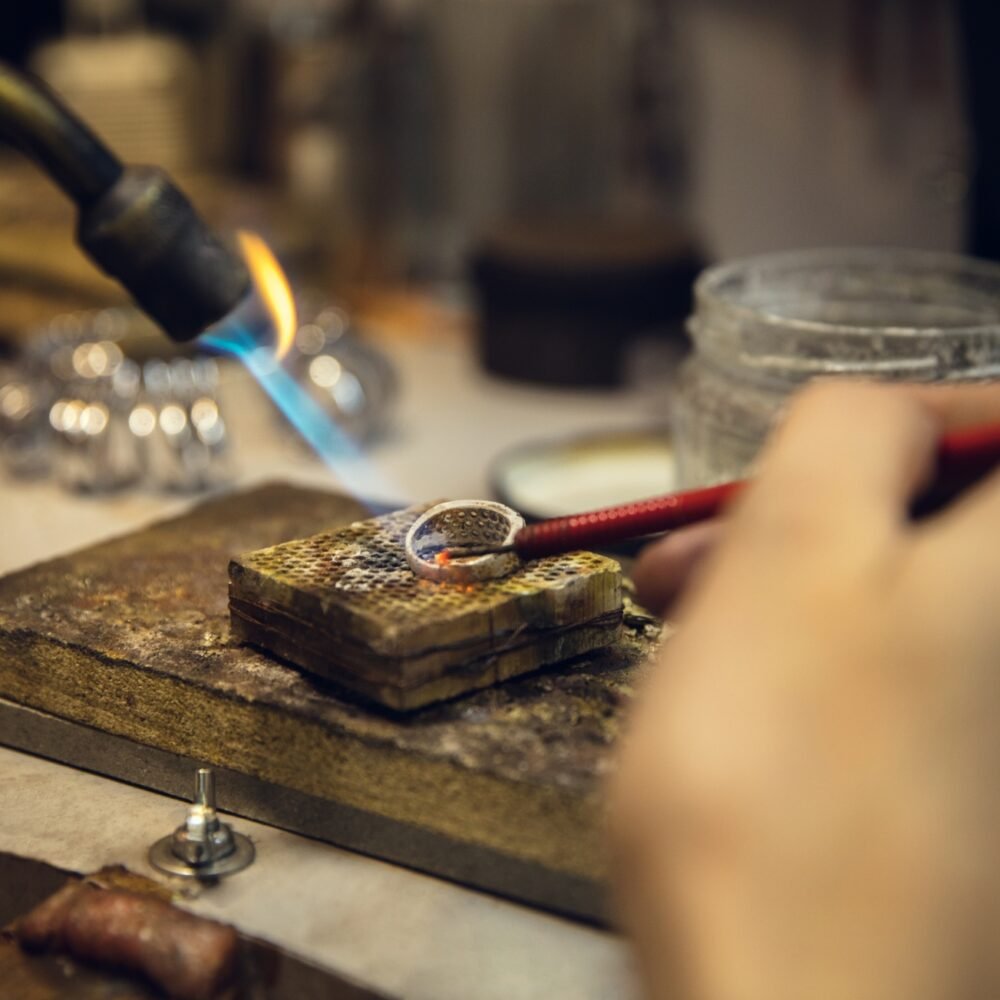 Artisan crafting a piece of jewelry, showcasing the intricate process of design and production by a responsible jewelry vendor,