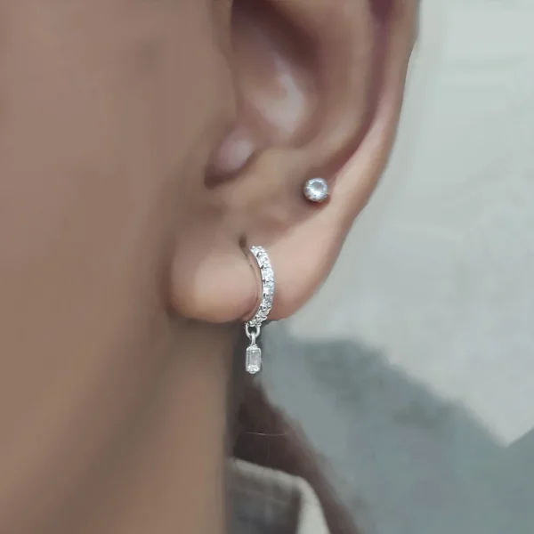 Small sterling silver huggie hoops with dangling baguette lab grown diamond charm