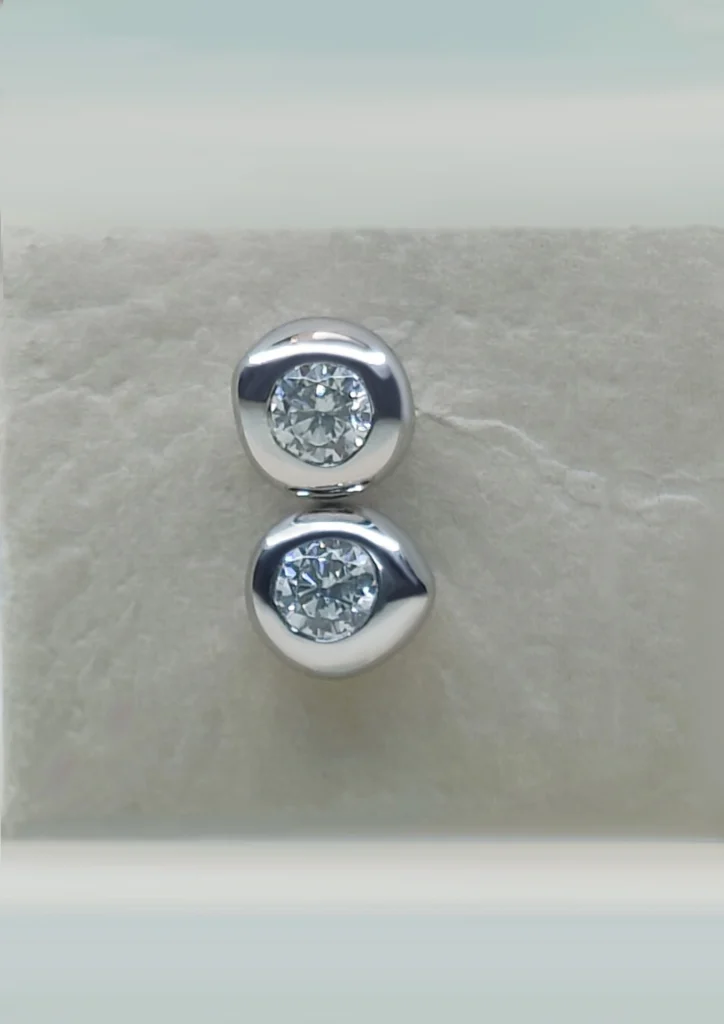 Sterling silver stud earrings with round brilliant-cut diamonds on a light background